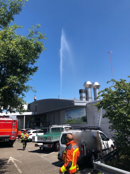 Sprinklerfontäne über Geschäftsgebäude